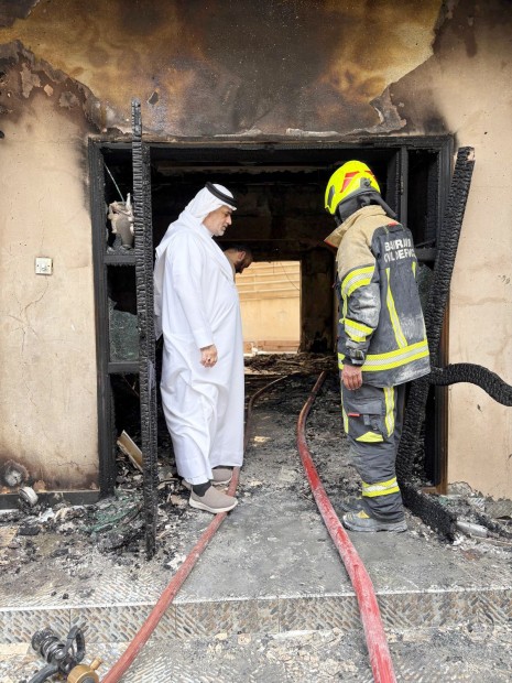 Firemen and officials inspect the damage after a house in Daih caught fire yesterday. The Civil Defence said three people have been rescued.